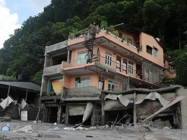 A man inspects his house after it was damaged by a landslide at Trishuli Bazaar, Nuwakot