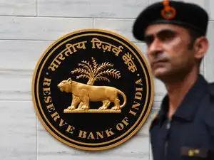 FILE PHOTO: A man walks past the Reserve Bank of India (RBI) logo outside its headquarters in Mumbai