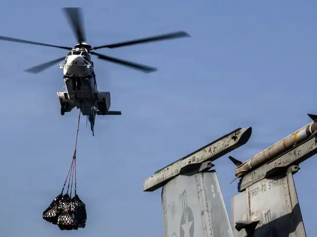 Helicopter delivers supplies to aircraft carrier USS Abraham Lincoln