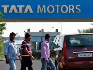 FILE PHOTO: FILE PHOTO: A vehicle drives past three men walking out of a Tata Motors car plant at Sanand