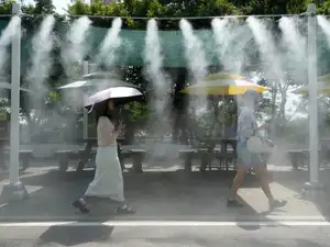 Visitors pass by the cooling fog device at Gwangmyeong Cave tourist site in Gwangmyeong, South Korea, Aug. 6, 2026.