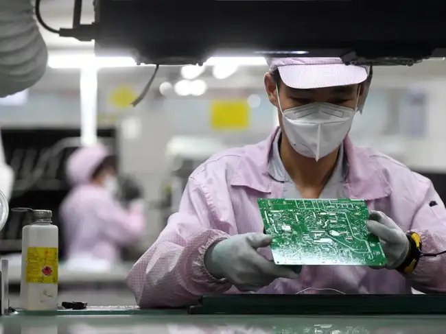 FILE PHOTO: Employee inspects a circuit board at a Gree factory in Wuhan