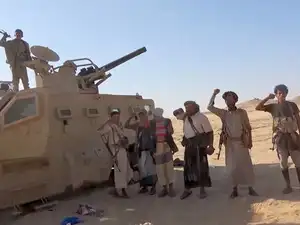 FILE PHOTO: Iran-aligned Houthi fighters pose next to a captured vehicle following what the source described as an attack on Saudi-backed forces in the location given by the source as al Jawf