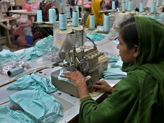 A garment worker works inside the sewing section of a garment factory in Ashulia