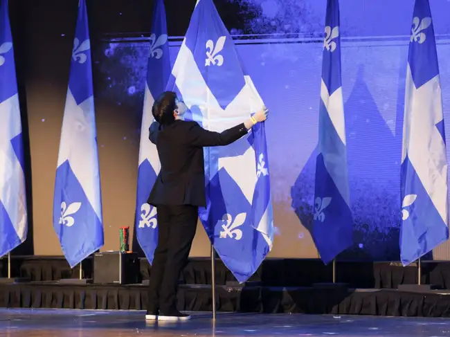 A worker arranges a Quebec flag at the election night headquarters of Parti Quebecois (PQ) leader Paul St-Pierre Plamondon in Montreal, Quebec, Canada October 5, 2026.