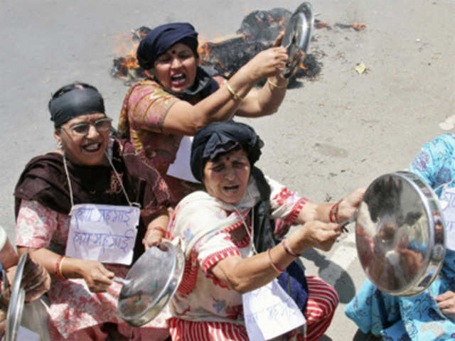 Demonstrators bang kitchen utensils and shout slogans