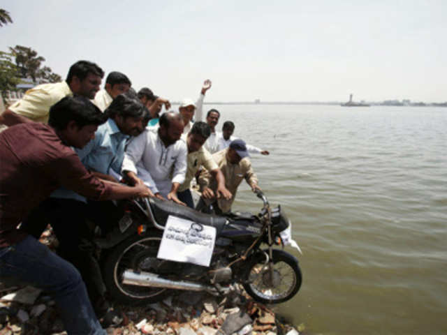 TDP activists throw a motorcycle into the Sagar lake