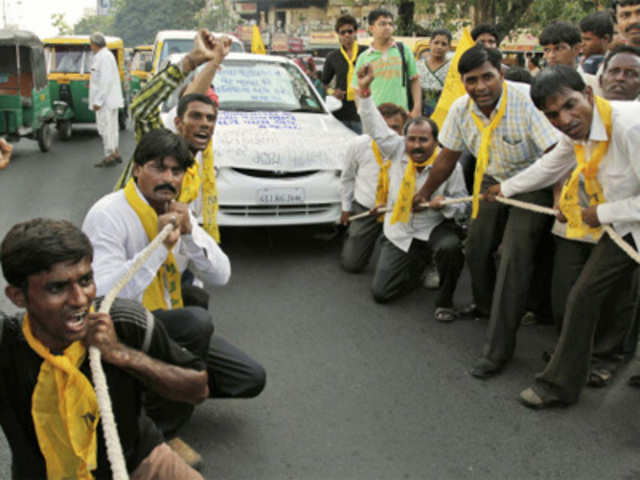 MJP supporters use rope to pull a car while protesting