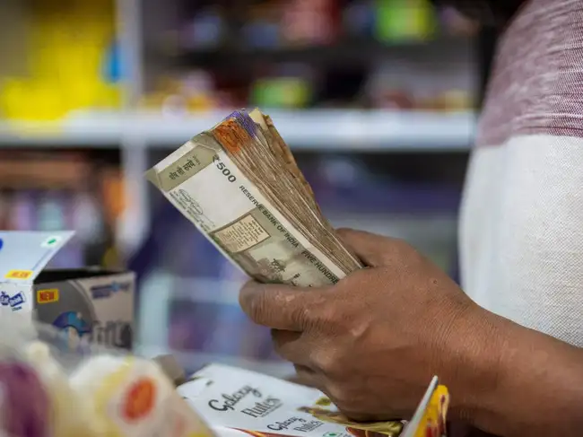 A man holds Indian currency notes inside a shop in New Delhi, India, April 3, 2025.