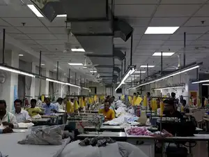 Garment workers stitch clothes at a textile factory in Noida