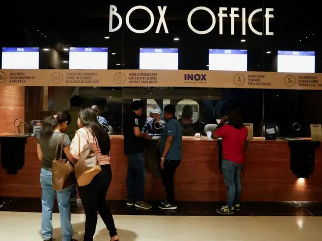 People wait in queue to purchase movie tickets at an INOX multiplex cinema hall inside a shopping mall in Kolkata