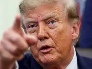 US President Donald Trump points, as he makes a joint appearance with Vice President JD Vance (not pictured) in the Oval Office to announce a whistleblower program to encourage the public to report