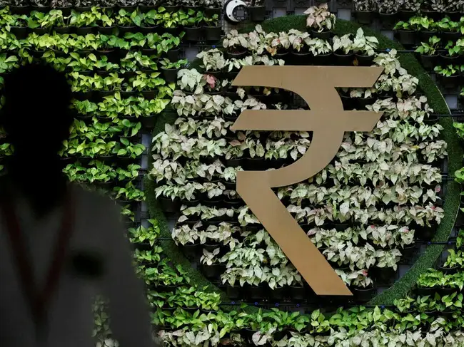 FILE PHOTO: A man walks past an Indian Rupee symbol installation at the Reserve Bank of India (RBI) headquarters in Mumbai, India, August 5, 2026.