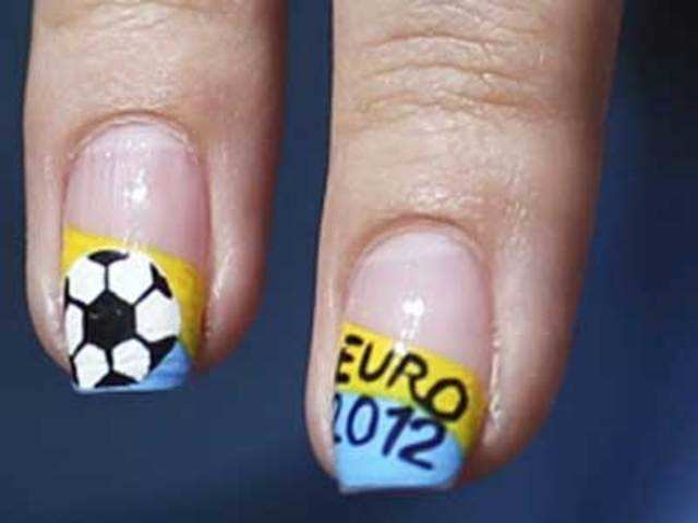 A volunteer shows nails painted with the colours of the Ukrainian flag and some drawings related to Euro 2012