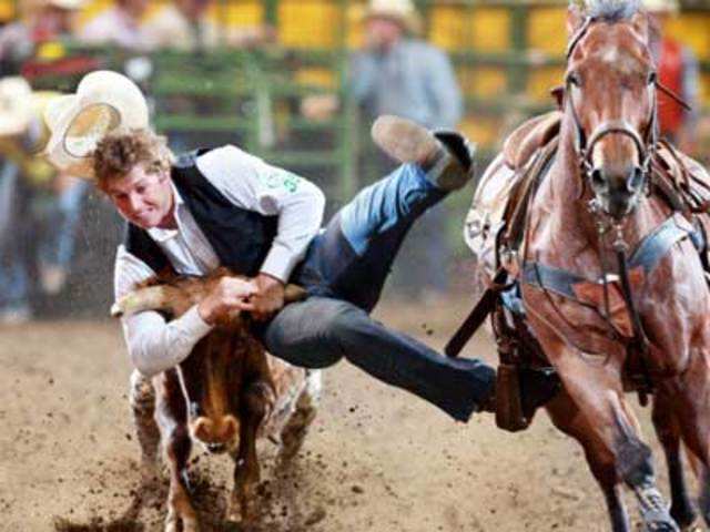 Hastings College steer wrestler Richard Coats leaps from his horse