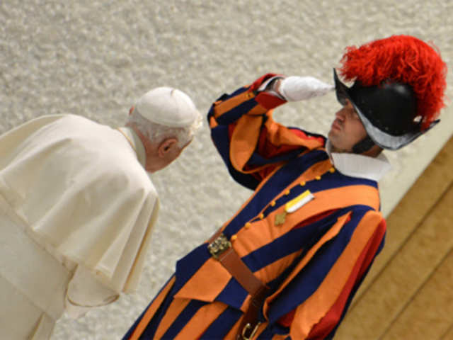 Pope Benedict XVI (L) leaves past a Swiss guard 