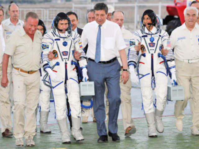 ISS crew members walk to board the Soyuz TMA-05M spacecraft