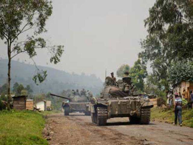 Congolese army tanks retreat through the village of Rugari