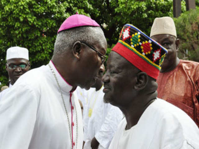 Archbishop of Ouagadougou Philippe Ouedrago (L) wishes a good Eid al-Fitr to Burkinabe muslims