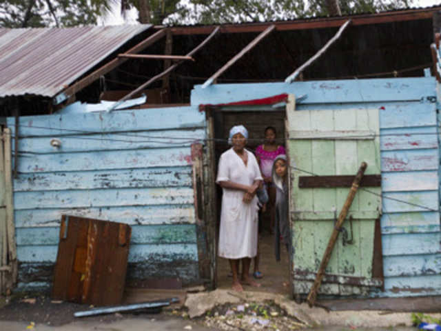 A woman stands inside her house after the passage of Tropical Storm Isaac, in Barahona
