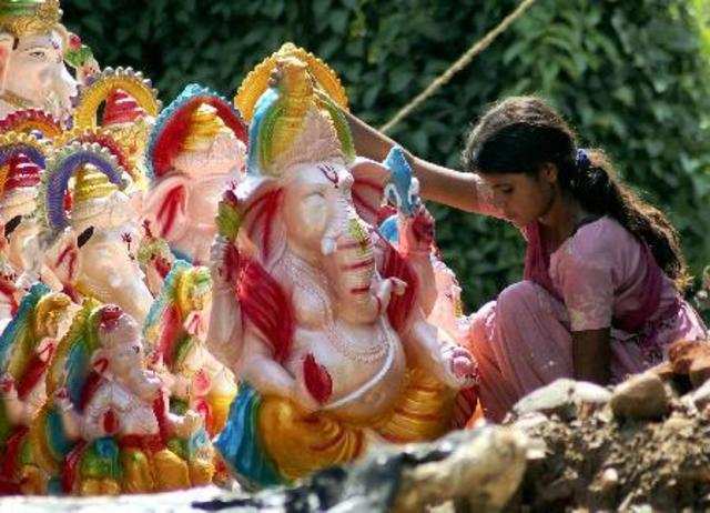 Jammu: A girl arranges idols of Lord Ganesh at a workshop ahead of the Ganesh fe...