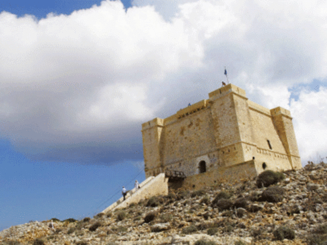 Tourists descend the stairs of Santa Marija Tower on the Maltese island of Comino