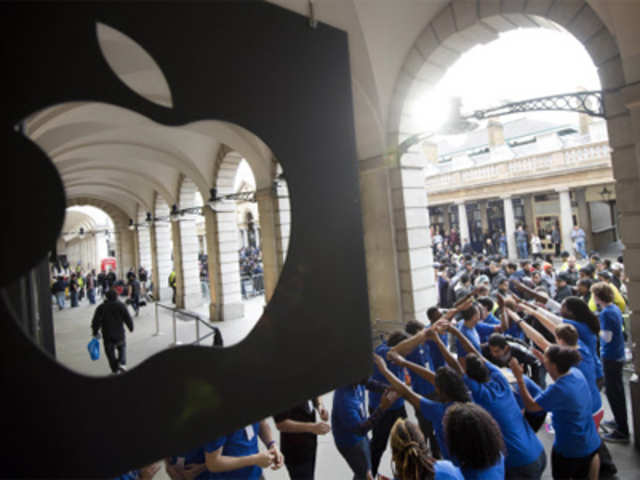Apple Store employees create a tunnel for customers as they are allowed into the shop to buy the new iPhone 5 smartphone
