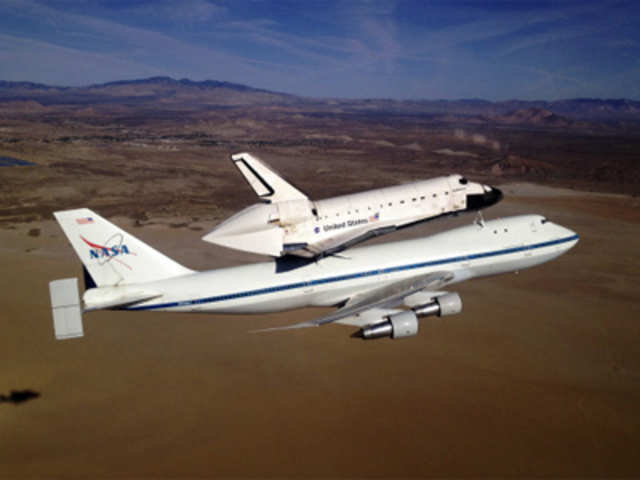 Space Shuttle Endeavour and its 747 carrier aircraft soars northward over Rosamond Dry Lake 