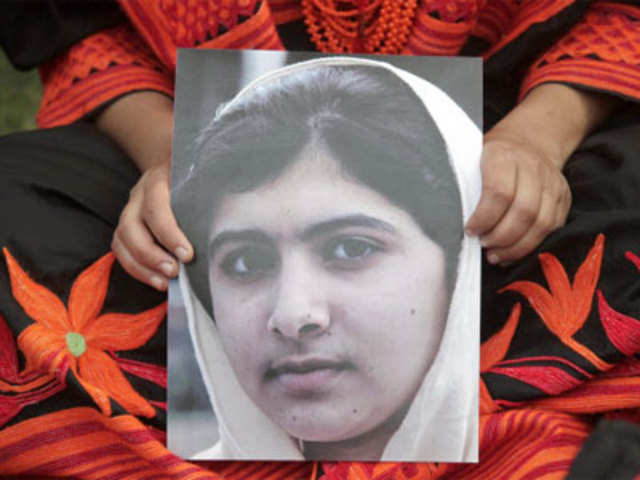 A student holds an image of Malala Yousufzai, who was shot on Tuesday by the Taliban