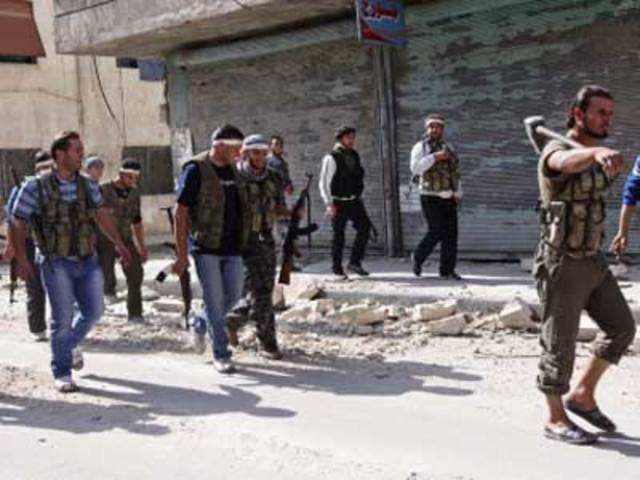 Free Syrian Army fighters walk in Aleppo's al-Huluk district