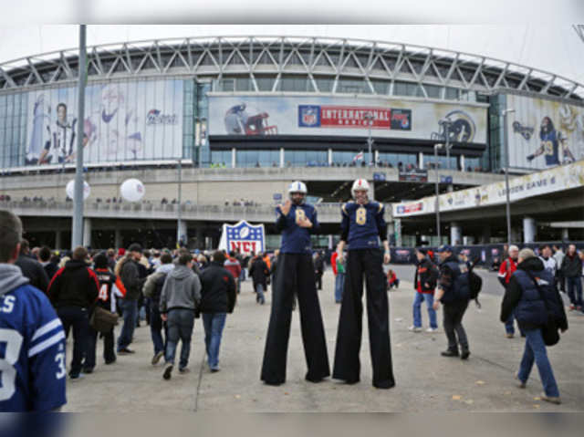 Performers on stilts welcome spectators prior to a NFL football game