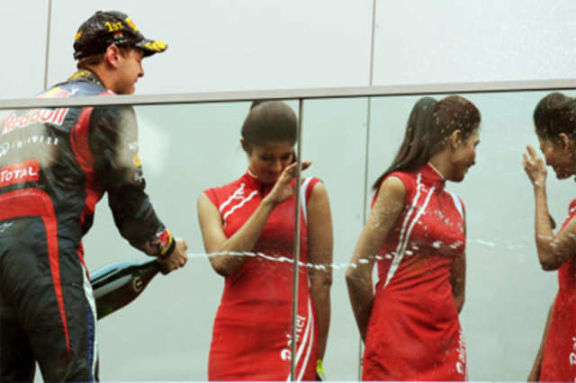 F1 Driver Sebastian Vettel celebrates with pit girls at F-1 Indian Grand Prix
