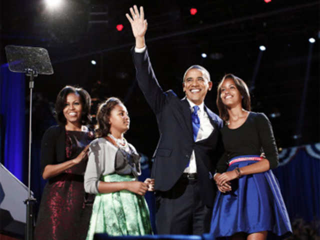 US President Barack Obama gathers with his wife Michelle Obama and daughters