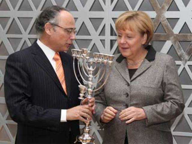 German Chancellor Angela Merkel is presented a Chanukah candle holder
