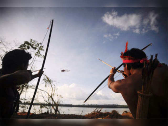 Indigenous people point their bows and arrows
