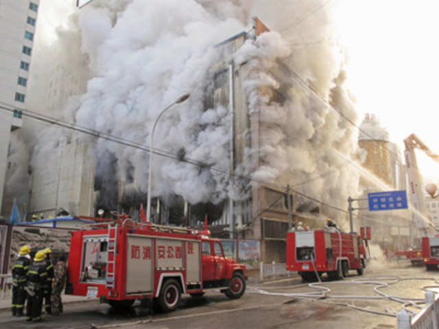 Firefighters and rescuers try to extinguish a fire in downtown Yan'an, Shaanxi province, China