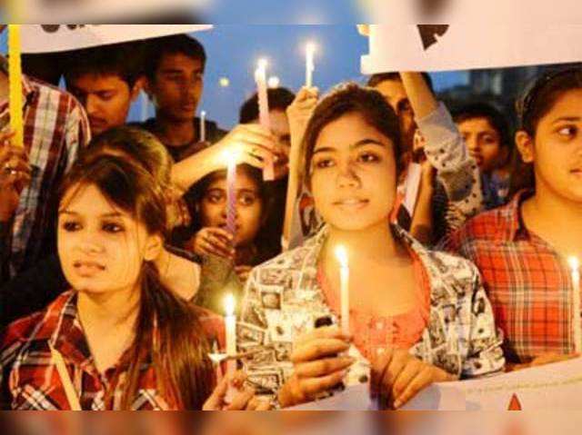 Protesters hold candles and placards in Ahmedabad