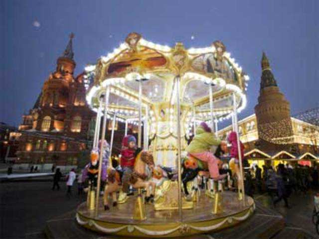Children ride a carousel at the Strasbourg Christmas Market in Moscow