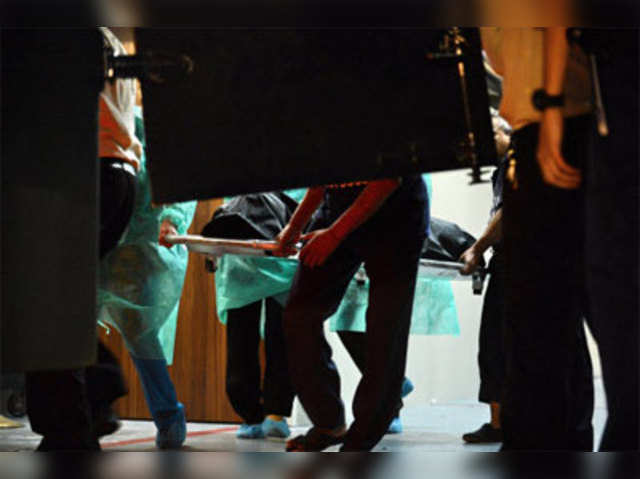 Hospital staff carry the body of gang-rape victim