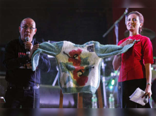 Presenters show a sweater made by Aung San Suu Kyi
