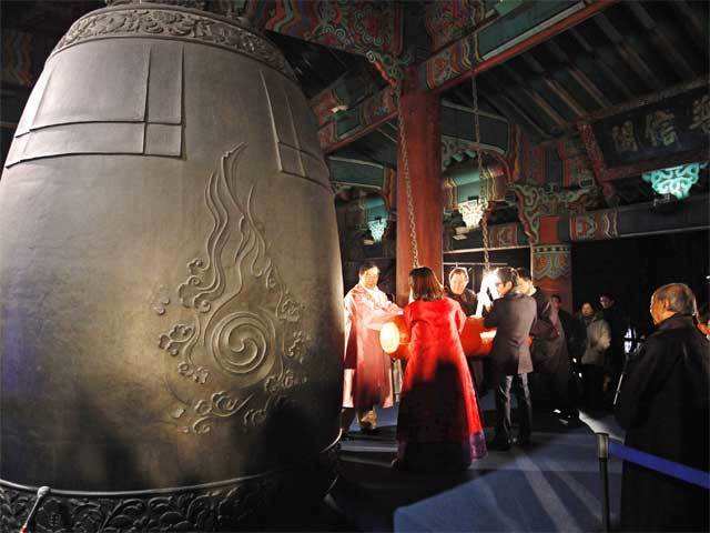Participants hit a huge traditional bell to welcome the New Year
