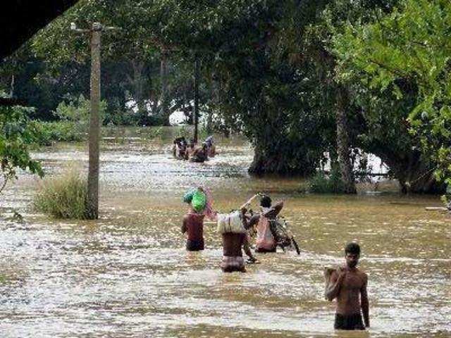 Kendrapada: People wade through a flooded village after Cyclone Phailin triggere...
