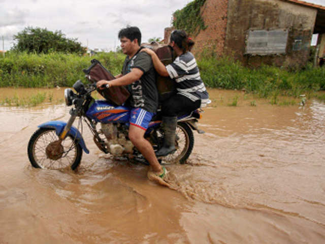 A couple rides with luggage on a motorcycle in  Trinidad