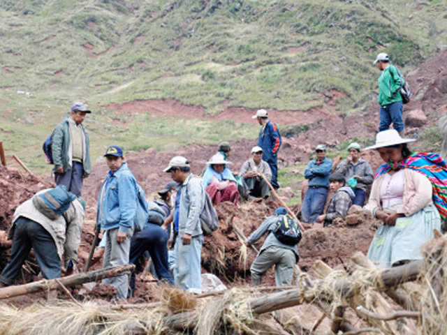 Farmers dig through  mud in search of survivors in Bolivia