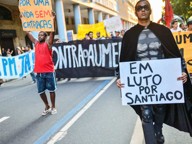 .A demonsrtator holds a sign reading 'In mourning for Santiago'