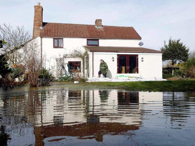 Dave Donaldson stamps down sandbags outside his flooded home at Burrowbridge