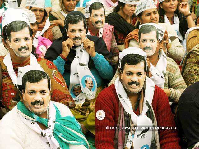 AAP supporters hold Arvind Kejriwal’s mask