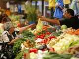 People buy vegetables in a market in Bucharest