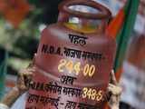 Activist holds a placard of a cooking gas cylinder