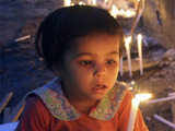 Child holds a candle during a prayer meeting